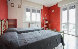two beds in a room with red walls at Gorgeous Apartment In Corsanico With House A Panoramic View in Corsanico-Bargecchia