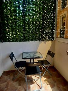 tavolo e sedie di fronte a una parete verde di Apartments Kaludjerovic a Herceg-Novi