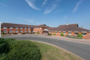 an empty street in front of a brick building at Supreme Inns in Swineshead