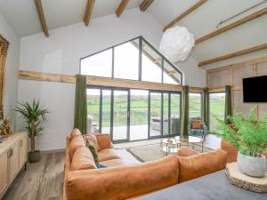 a living room with a couch and a large window at Barcud Coch - Red Kite in Welshpool