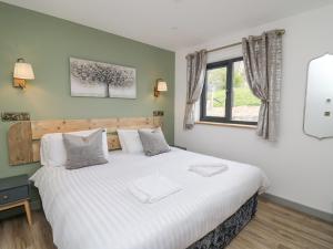 sypialnia z dużym białym łóżkiem i oknem w obiekcie Barcud Coch - Red Kite w mieście Welshpool