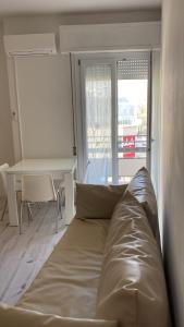 - un canapé dans une chambre avec un bureau et une fenêtre dans l'établissement SoleMare, à Bellaria-Igea Marina