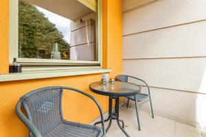 a small table and two chairs sitting on a porch at Seaside Apartment with Parking in Sopot by Renters in Sopot