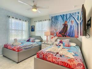 - 2 lits dans une chambre avec un tableau mural dans l'établissement Top Villas - Storey Lake Resort 448, à Kissimmee