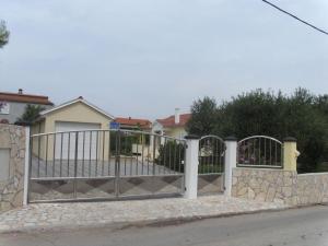 a gate in front of a house at Modernes Ferienhaus in Dobropoljana mit Terrasse, Garten und Grill in Dobropoljana +14 photos
