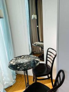 a table and two chairs and a table and a mirror at Charming Tiny Garden House for two in Lucerne