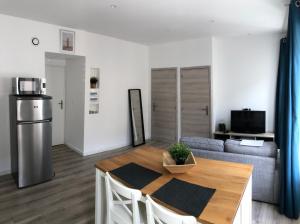 a kitchen and living room with a table and a couch at Joli logement au centre de Trévoux in Trévoux +2 photos