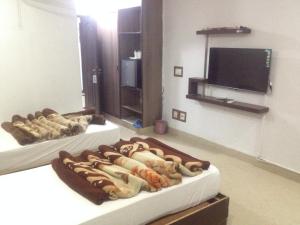 Cette chambre comprend 2 lits et une télévision à écran plat. dans l'établissement Five Mounts Hotel And Restaurant, à Multan