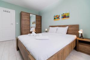 une chambre avec un grand lit avec des draps blancs dans l'établissement Cozy 2-bed Apartment, à Plovdiv