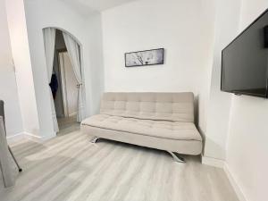 a white living room with a couch and a flat screen tv at Casa Linda in Corsico