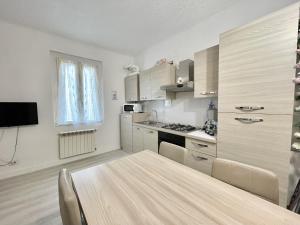 a kitchen with a wooden table in a room at Casa Linda in Corsico