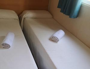 - 2 lits dans une chambre avec 2 serviettes en papier dans l'établissement Camping Sant Salvador, à Coma-ruga