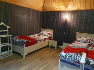 two beds in a room with wooden walls at Luxury Forestside Villa in Quba