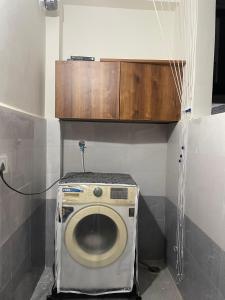 a bathroom with a toilet with a wooden cabinet above it at Vinayaka Villas in Hyderabad