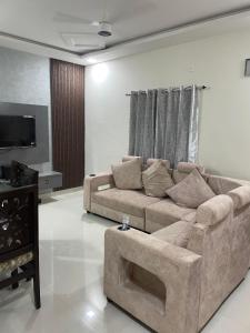 sala de estar con sofá y TV en Vinayaka Villas, en Hyderabad