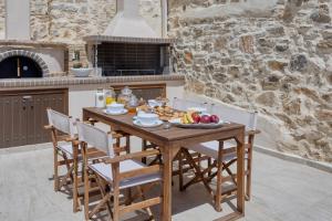 una mesa de madera con un plato de fruta. en Villa Charaso Maritina private pool by Estia, en Kharasón