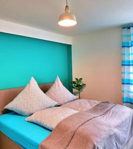 1 dormitorio con 1 cama con pared azul en Garten-Blick-Baldeneysee, en Essen