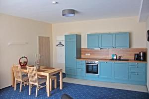 a kitchen with blue cabinets and a wooden table at Am Apfelbaum 4 Pers in Röbel