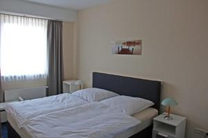 a bedroom with a white bed with a window at Am Apfelbaum 4 Pers in Röbel