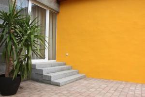 a yellow building with stairs next to a window at Am Apfelbaum 4 Pers in Röbel