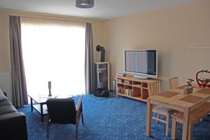 a living room with a table and a television at Am Apfelbaum 4 Pers in Röbel +16 photos