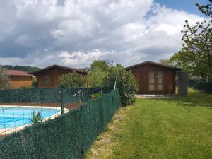 a house with a fence next to a swimming pool at L'escale en Dordogne in Saint-Antoine-de-Breuilh