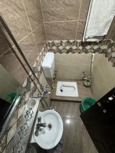 ein kleines Bad mit einem Waschbecken und einem WC in der Unterkunft Millat Hotel in Islamabad