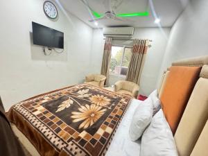 ein Krankenhauszimmer mit einem Bett und einem TV in der Unterkunft Millat Hotel in Islamabad