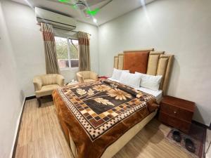 ein Schlafzimmer mit einem großen Bett und einem Stuhl in der Unterkunft Millat Hotel in Islamabad