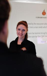 Una donna è in piedi davanti a uno schermo di Flåmsbrygga Hotel a Flåm