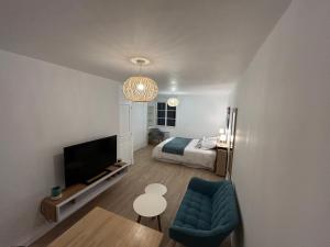 a small living room with a bed and a tv at Le Clos des Lilas in Graves