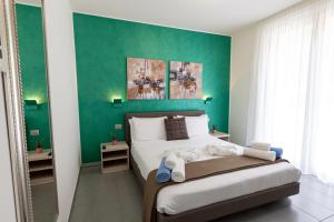 een slaapkamer met een groot bed met een groene muur bij Bellagio Village- 4 Apartments by the lake - Seasonal Warm Pool and Sauna in Oliveto Lario