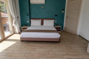 ein Schlafzimmer mit einem Bett und einer grünen Wand in der Unterkunft Bellagio Village- 4 Apartments by the lake - Seasonal Warm Pool and Sauna in Oliveto Lario