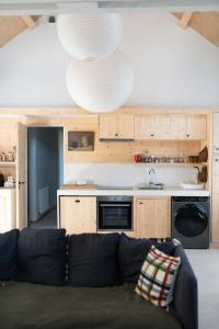 a living room with a couch and a kitchen at Lofts L'Écluse, parking gratuit in Saint-Valery-sur-Somme