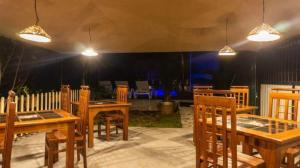 un patio con tavoli, sedie e luci in legno di Lotus villa a Weligama