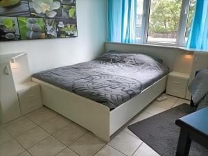 a small bed in a room with a window at Three bedroom apartment in Heerlen in Heerlen