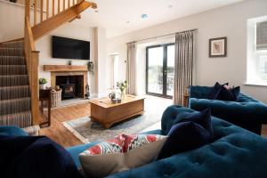 a living room with a blue couch and a fireplace at Mill Cottage, Brockmill Farm in Berwick-Upon-Tweed