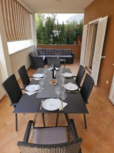 una mesa con sillas y copas de vino en un patio en Apartman Garden Novalja, en Novalja