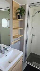 a bathroom with a sink and a shower at Modern 6P Tiny SolHouse 6 - Near Groningen in Kropswolde