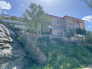 een huis bovenop een rotsachtige heuvel bij Guetali du Village in Monacia-dʼAullène