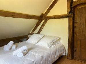 um quarto com uma cama com lençóis brancos e almofadas em Les Petites Bergeonnières em Courmemin