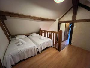 um quarto com 2 camas e lençóis brancos em Les Petites Bergeonnières em Courmemin