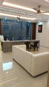 - un hall doté d'un mobilier blanc, d'une table et de chaises dans l'établissement Sri Sai Grand IN, à Bangalore