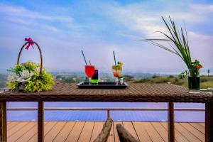 uma mesa com duas bebidas no topo de um deque em Wabi Sabi Resort, Igatpuri em Igatpuri