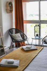 une chambre avec deux chaises, une table et une fenêtre dans l'établissement Studio avec parking vue sur la Cité de Carcassonne, à Carcassonne