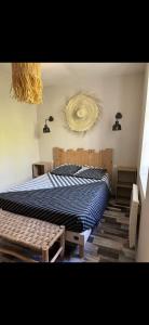 ein Schlafzimmer mit einem Bett mit einer Bettdecke an der Wand in der Unterkunft L’oustau St Bernard in Saint-Rémy-de-Provence