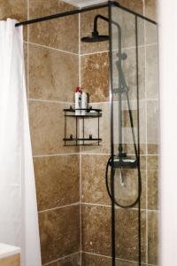 um chuveiro na casa de banho com uma cabina de duche envidraçada. em Studio avec parking vue sur la Cité de Carcassonne em Carcassonne