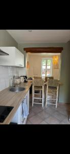 eine Küche mit einem Waschbecken und einem Tisch mit Stühlen in der Unterkunft L’oustau St Bernard in Saint-Rémy-de-Provence