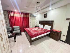 ein Schlafzimmer mit einem Bett und einem Stuhl darin in der Unterkunft Millat Hotel in Islamabad