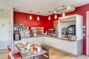 里永的住宿－里永艾斯酒店，一间厨房,拥有红色的墙壁和一张带食物的桌子